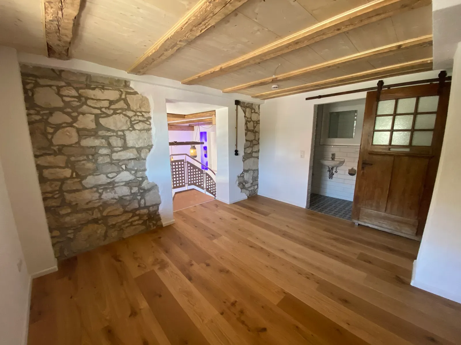 Sanierter Wohnraum mit Natursteinwand und Eichenboden