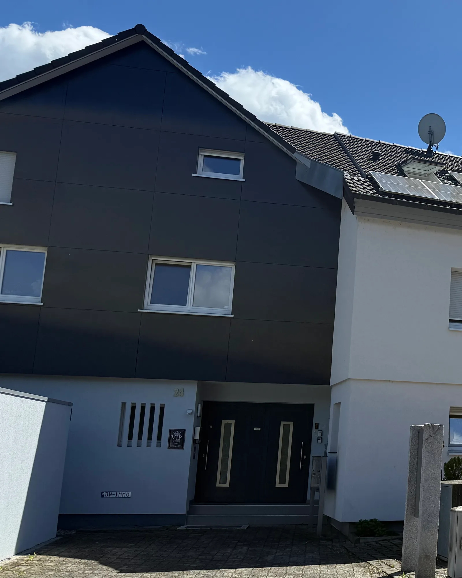 Eingang der DW Immobilien GmbH, Königsbergerstr. 24 in Weil am Rhein: dunkel verkleideter Giebel mit Hausnummer 24 und Eingangstür